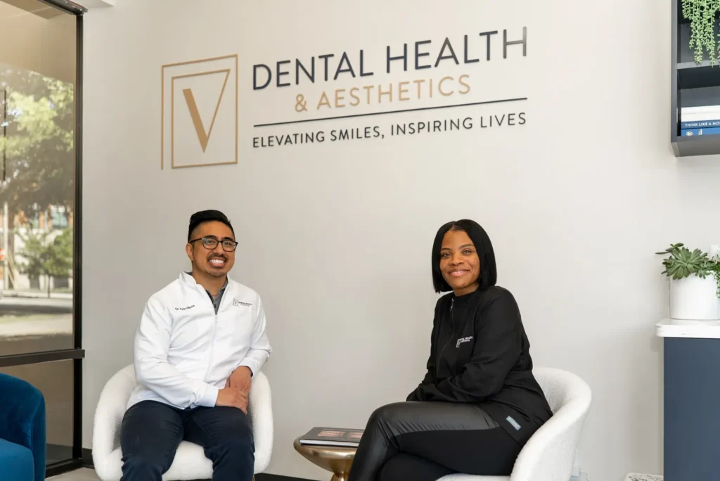 Dr. V and staff member smiling and sitting in the lobby of V Dental's office