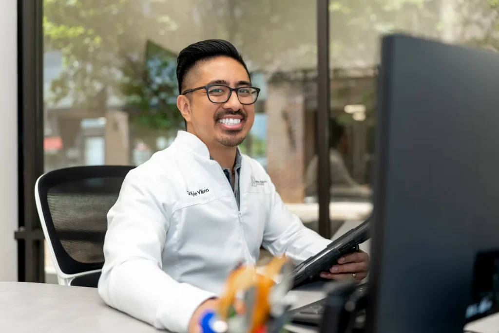 Dr. V smiling while sitting in the office