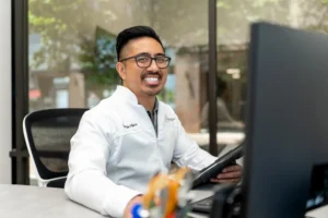 Dr. V smiling while sitting in the office
